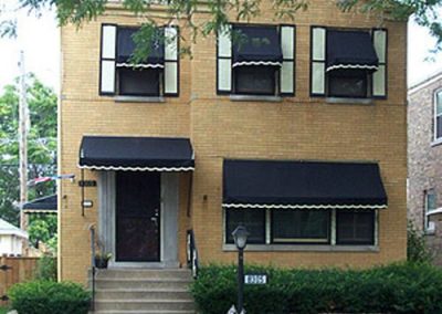 2 story home in Chicago with Black awnings with with trim